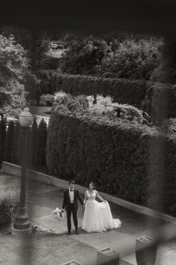 bride and groom walking through garden