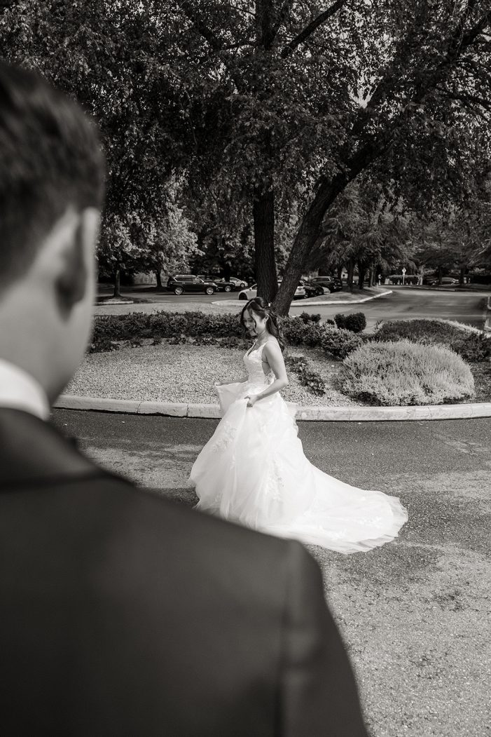 groom looks at bride in garden